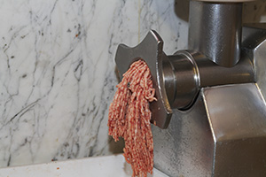 Mincing pork to make English sausages in Italy